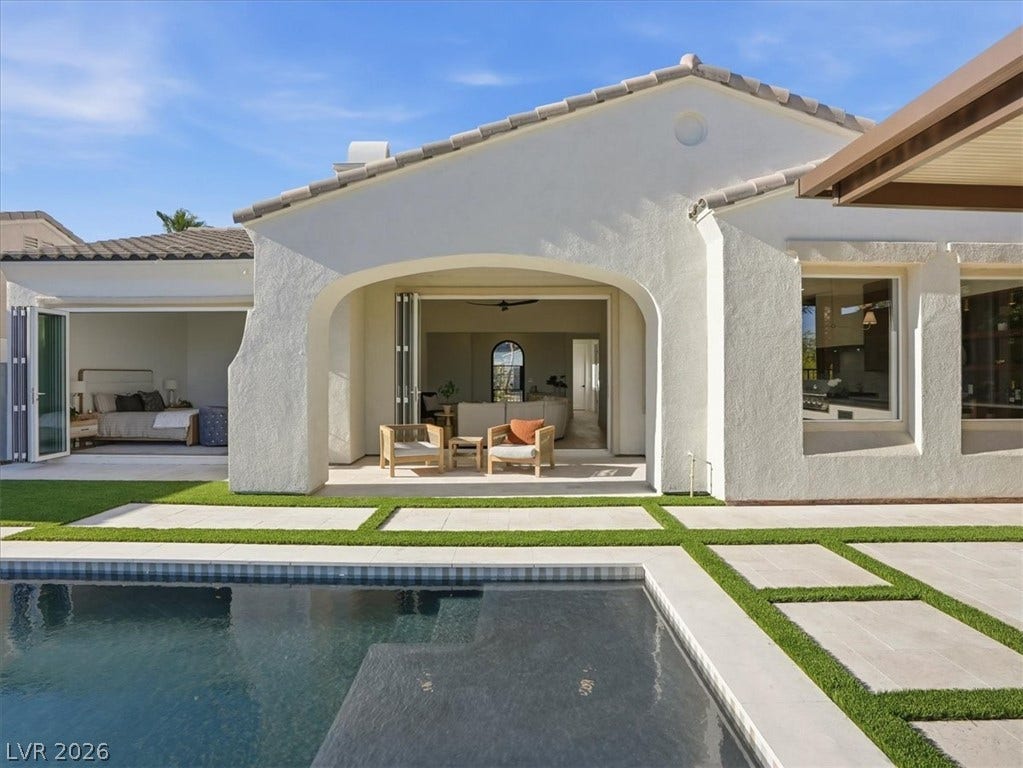 3074 Soft Horizon Way, Las Vegas, NV 89135 An inviting pool alongside a contemporary home with expansive glass doors offers seamless indoor-outdoor living.