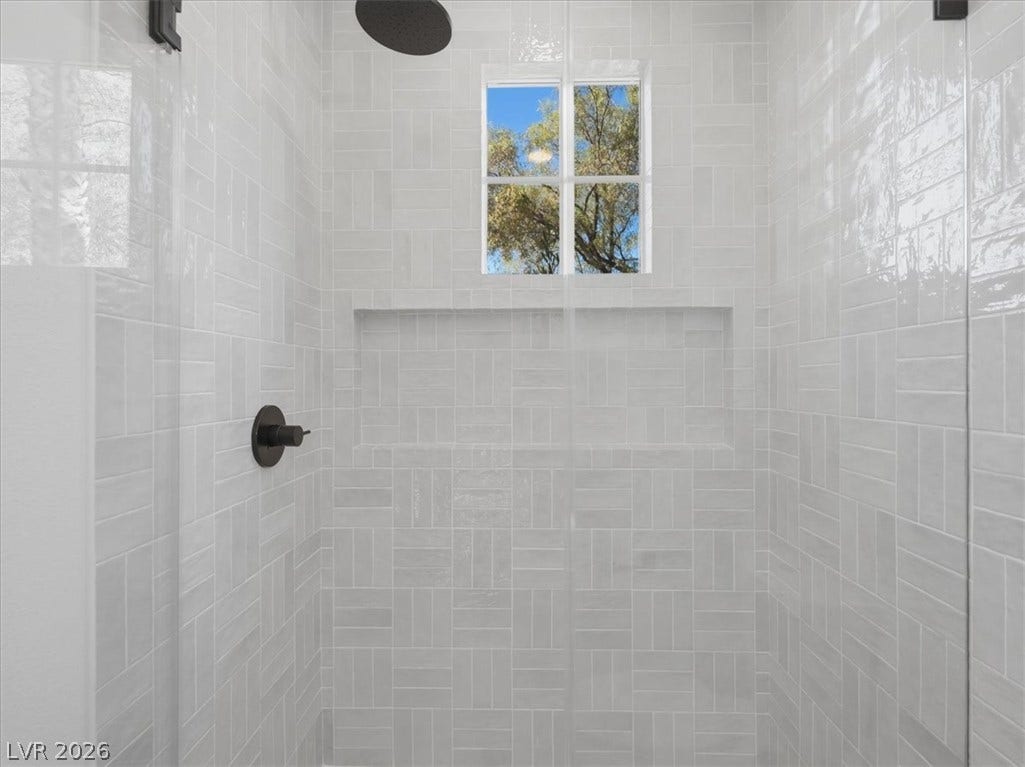 3074 Soft Horizon Way, Las Vegas, NV 89135 Modern shower with tile walls and a view to the outside.