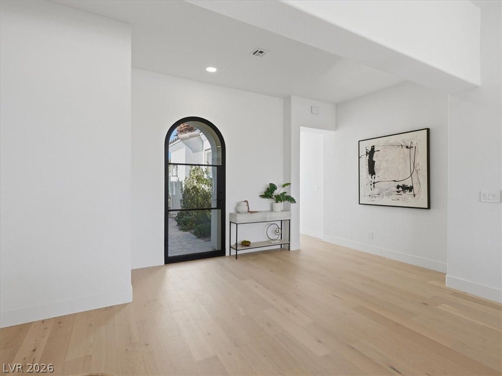 3074 Soft Horizon Way, Las Vegas, NV 89135 A chic arched glass door introduces a bright entryway with light-toned hardwood flooring.
