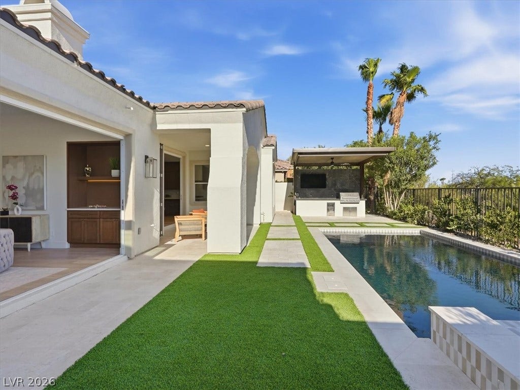 3074 Soft Horizon Way, Las Vegas, NV 89135 An inviting backyard oasis awaits with a sparkling pool and a fully equipped outdoor kitchen, perfect for entertaining.