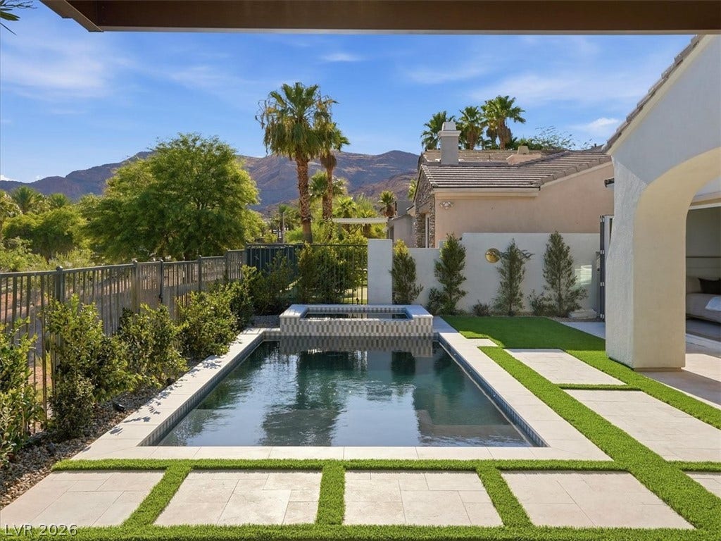 3074 Soft Horizon Way, Las Vegas, NV 89135 A private backyard oasis features a shimmering pool and spa, set against a desert mountain backdrop.
