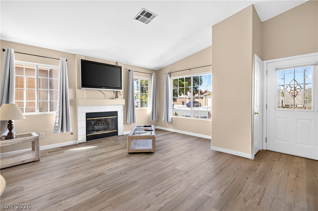 4633 Sophia Way, North Las Vegas, NV 89032 Vaulted ceilings and wide-plank flooring define this open living space anchored by a tiled fireplace.