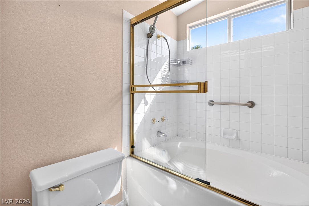 4633 Sophia Way, North Las Vegas, NV 89032 White wall tiles frame a relaxing soaking tub enclosed by brass-trimmed sliding glass doors.