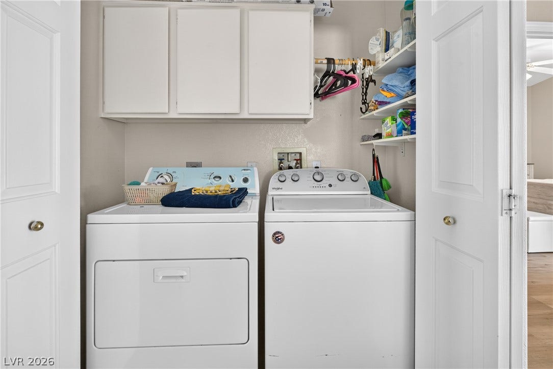 4633 Sophia Way, North Las Vegas, NV 89032 Functional laundry nook features built-in storage cabinets and open shelving above the appliances.