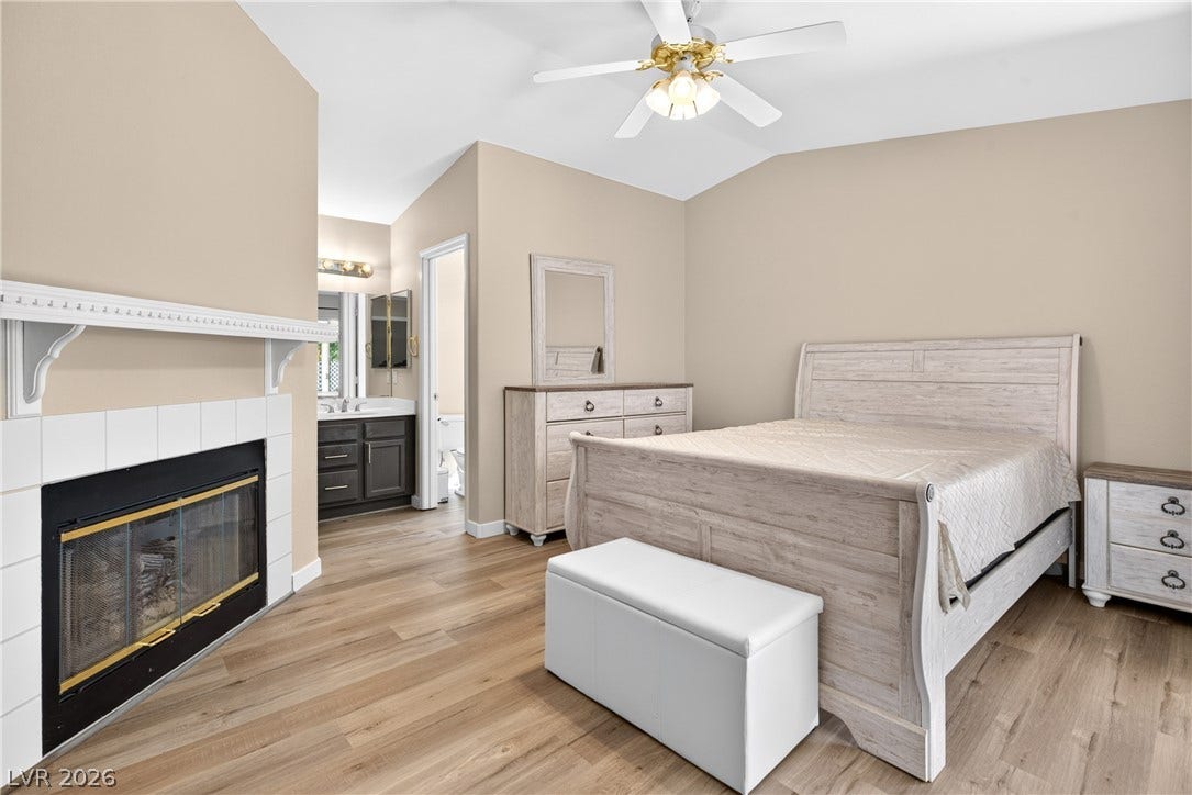 4633 Sophia Way, North Las Vegas, NV 89032 Warm wood flooring and a cozy fireplace create a welcoming atmosphere in this master suite.