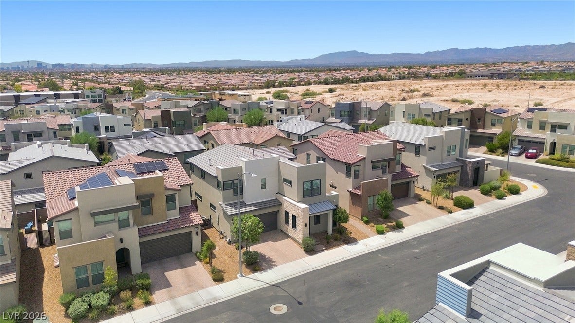 709 Emerson Creek Court, North Las Vegas, NV 89084 An aerial perspective reveals a contemporary neighborhood of desert homes under a wide-open sky.