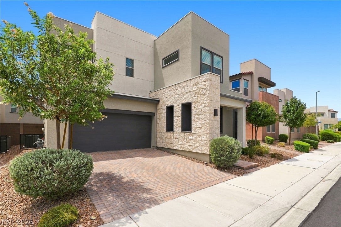 709 Emerson Creek Court, North Las Vegas, NV 89084 Modern architecture blends stucco and stone, creating an inviting faade with a paver driveway.