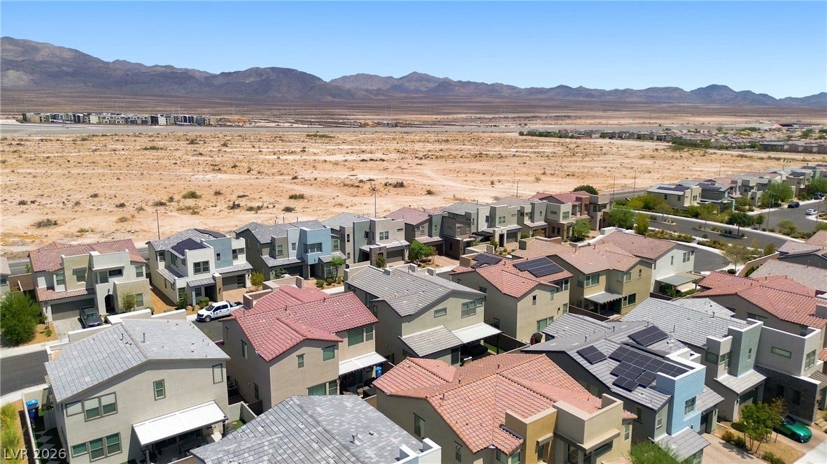 709 Emerson Creek Court, North Las Vegas, NV 89084 An aerial perspective showcases a new community of desert homes framed by distant mountains and open land.