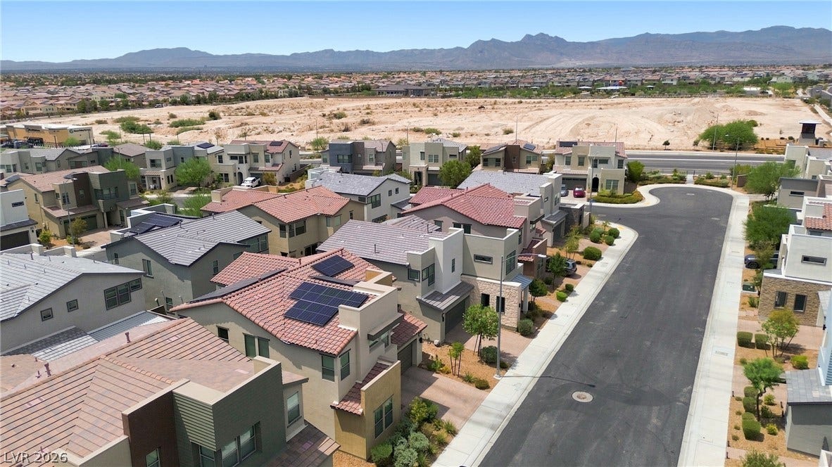 709 Emerson Creek Court, North Las Vegas, NV 89084 An aerial perspective reveals a vibrant community with modern homes nestled against a backdrop of distant mountains.