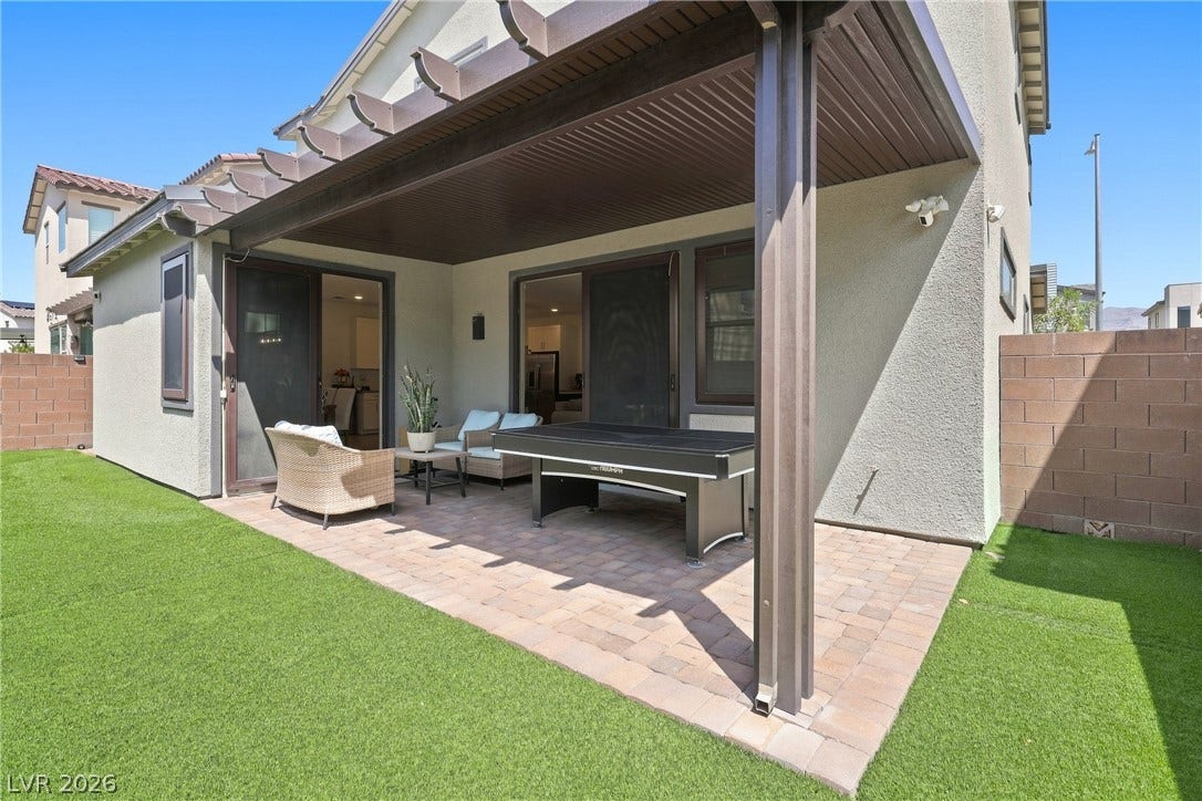 709 Emerson Creek Court, North Las Vegas, NV 89084 A private outdoor space with a paved patio and lush green turf awaits for leisure and entertainment.