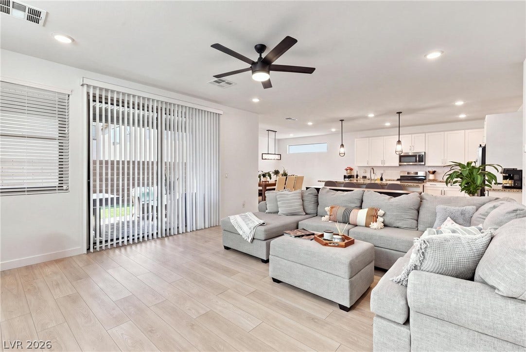 709 Emerson Creek Court, North Las Vegas, NV 89084 An inviting open-concept living area with light-toned flooring seamlessly connects to the kitchen and dining space.