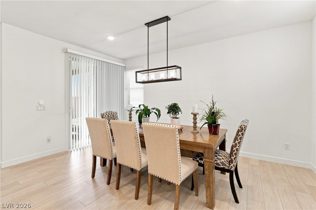 709 Emerson Creek Court, North Las Vegas, NV 89084 A contemporary dining room with light wood floors and a sleek rectangular chandelier.