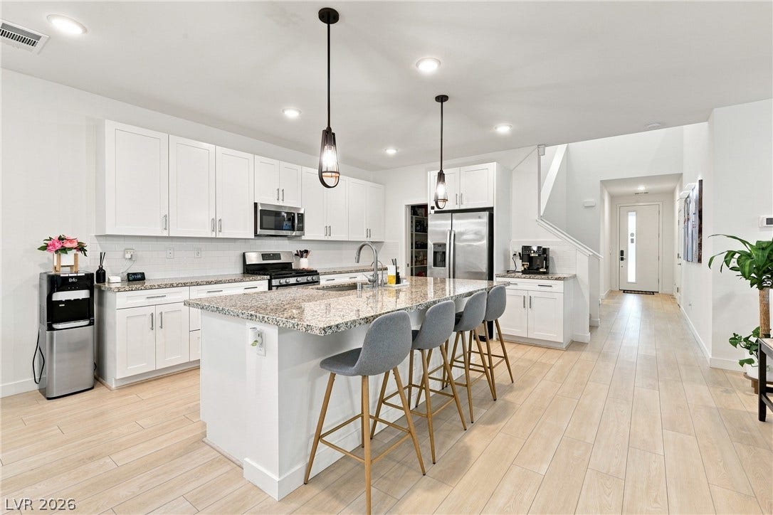 709 Emerson Creek Court, North Las Vegas, NV 89084 A well-lit, open-concept kitchen features a spacious granite island and light wood flooring.