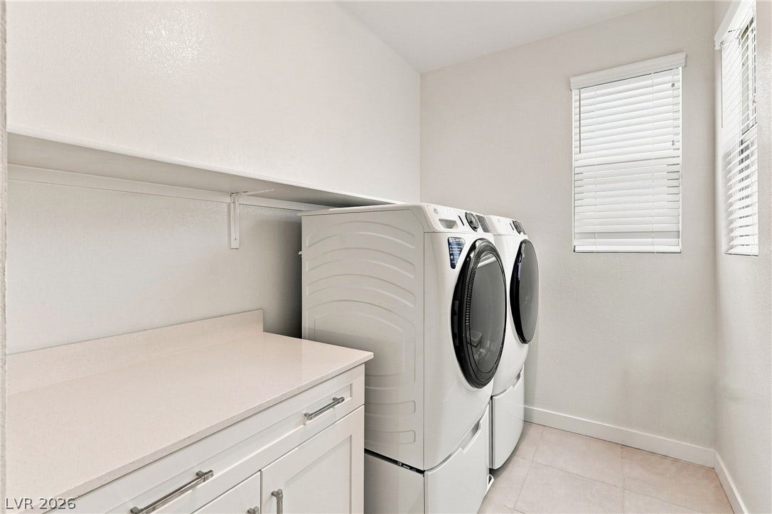 709 Emerson Creek Court, North Las Vegas, NV 89084 Functional laundry space featuring modern appliances and a convenient counter for folding.