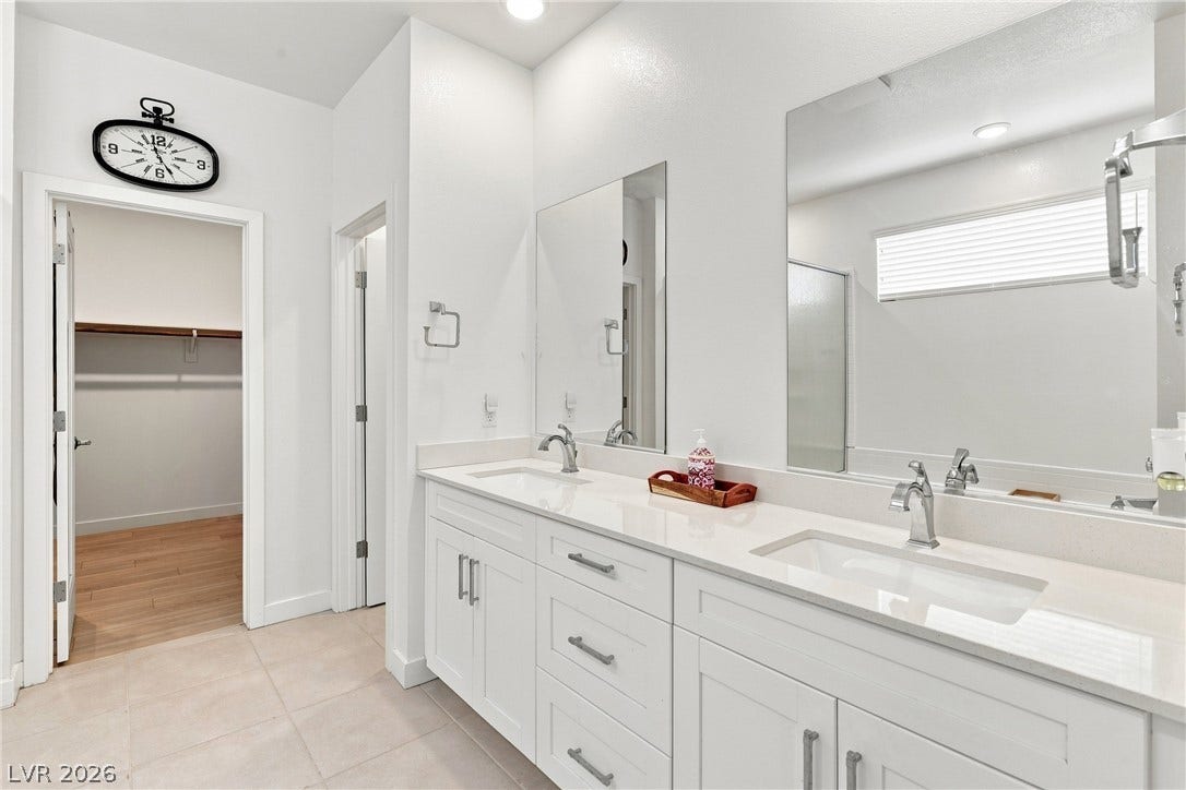 709 Emerson Creek Court, North Las Vegas, NV 89084 Clothes virtually removed. A well-appointed primary bathroom features dual vanities, generous mirror space, and an adjacent walk-in closet.