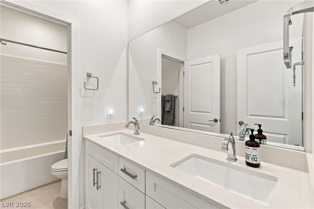 709 Emerson Creek Court, North Las Vegas, NV 89084 Double vanity with sleek fixtures offers ample counter space in this bright bathroom.