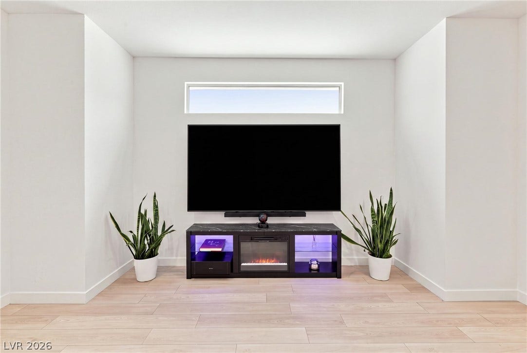 709 Emerson Creek Court, North Las Vegas, NV 89084 A chic media console with an electric fireplace anchors this modern living area.
