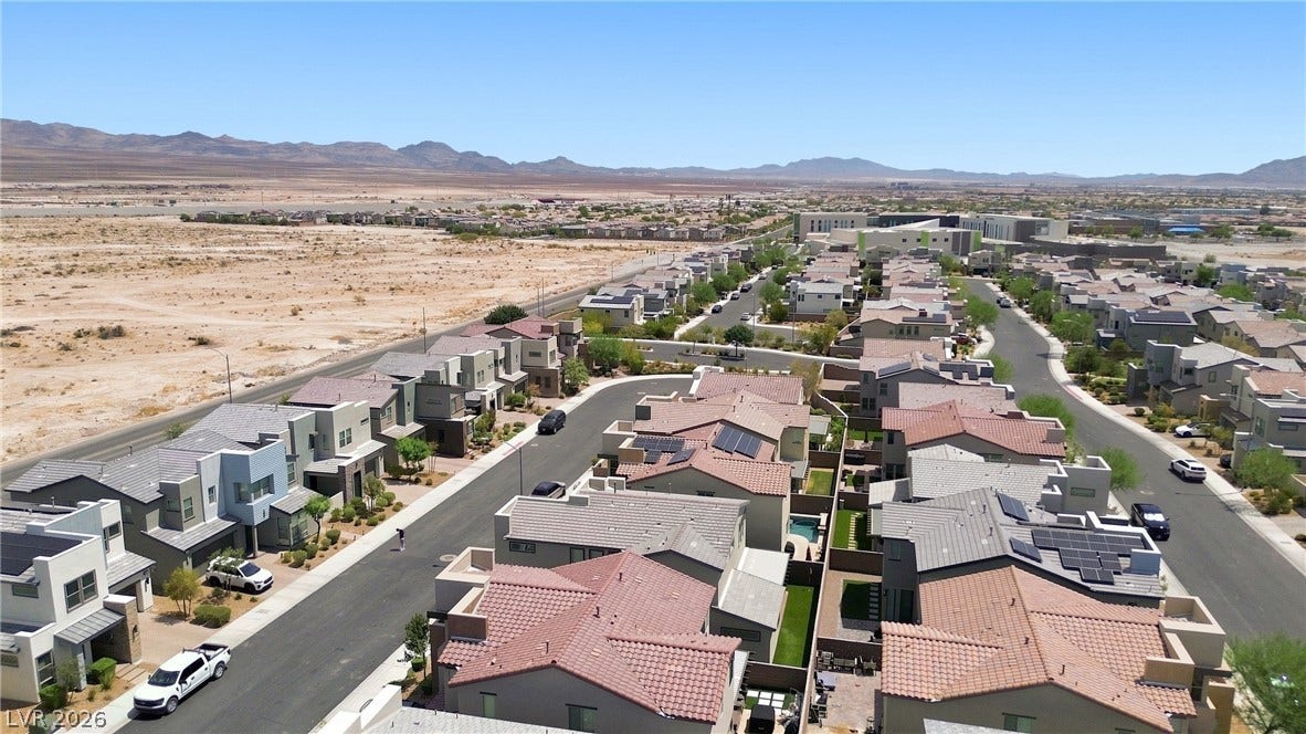 709 Emerson Creek Court, North Las Vegas, NV 89084 Aerial view showcasing a modern desert community with residential rooftops and mountain vistas.