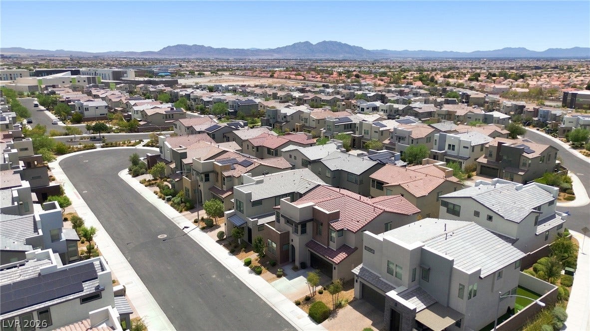 709 Emerson Creek Court, North Las Vegas, NV 89084 An aerial perspective showcases a well-planned residential community with contemporary homes, featuring solar panels and desert landscaping.