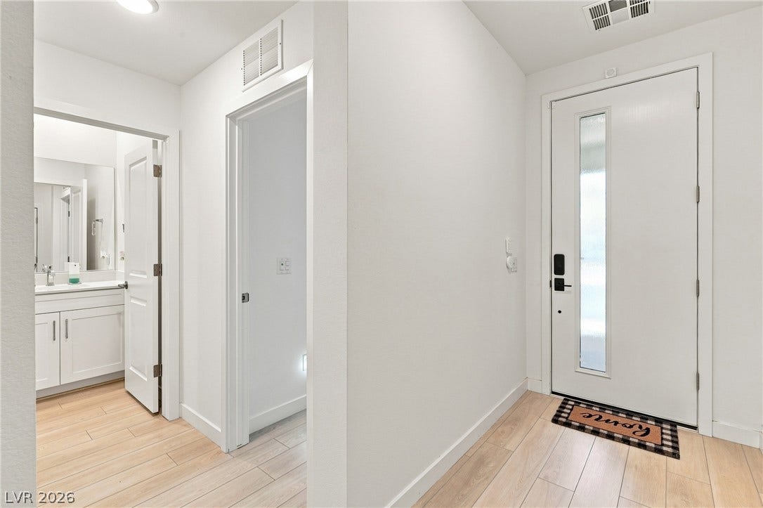 709 Emerson Creek Court, North Las Vegas, NV 89084 A well-lit entry hall with wood-look tile flooring leads to a modern front door with a frosted glass insert and a convenient half-bath.