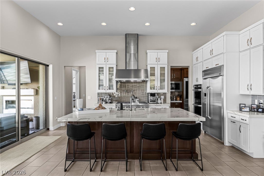 7851 W Wigwam Avenue, Las Vegas, NV 89113 Kitchen with glass insert cabinets, white cabinetry, a kitchen bar, and recessed lighting