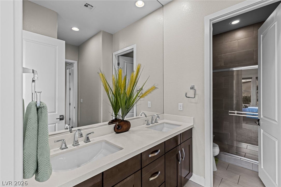 7851 W Wigwam Avenue, Las Vegas, NV 89113 Bathroom featuring double vanity, a shower stall, light tile patterned floors, and recessed lighting