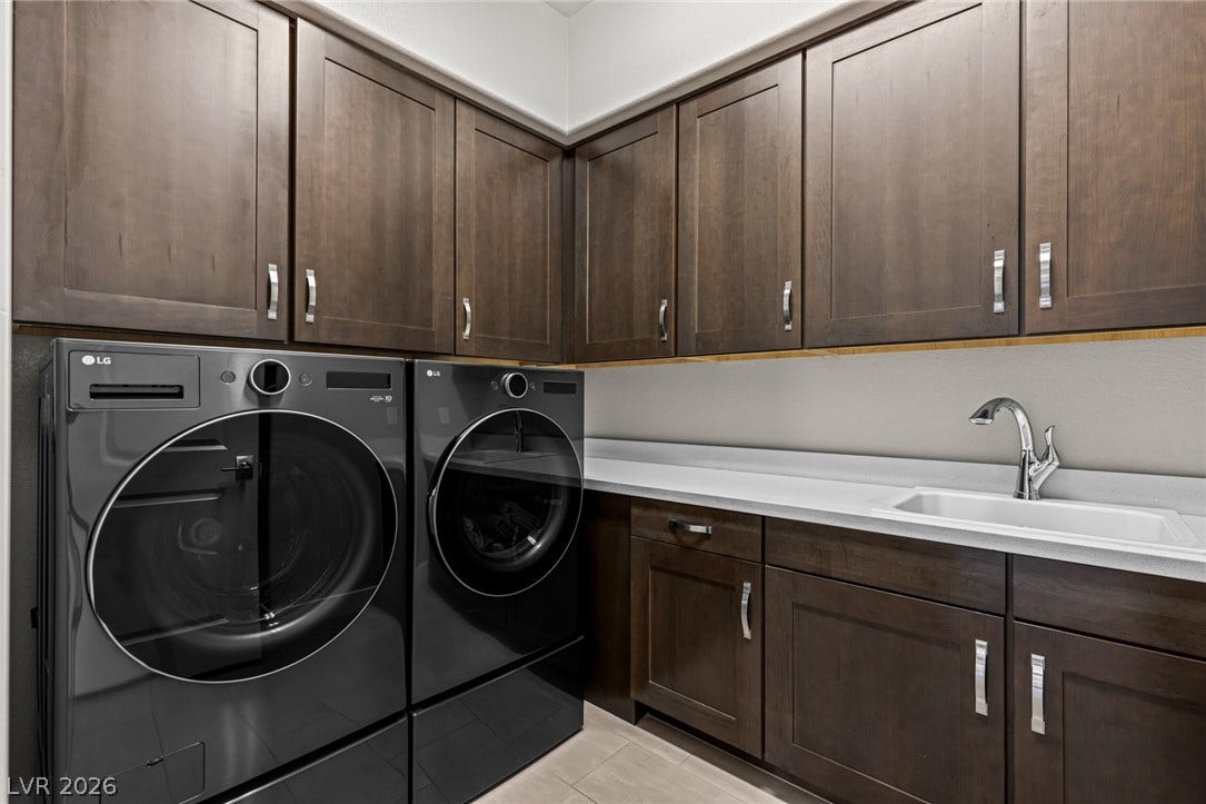 7851 W Wigwam Avenue, Las Vegas, NV 89113 Washroom featuring cabinet space and independent washer and dryer