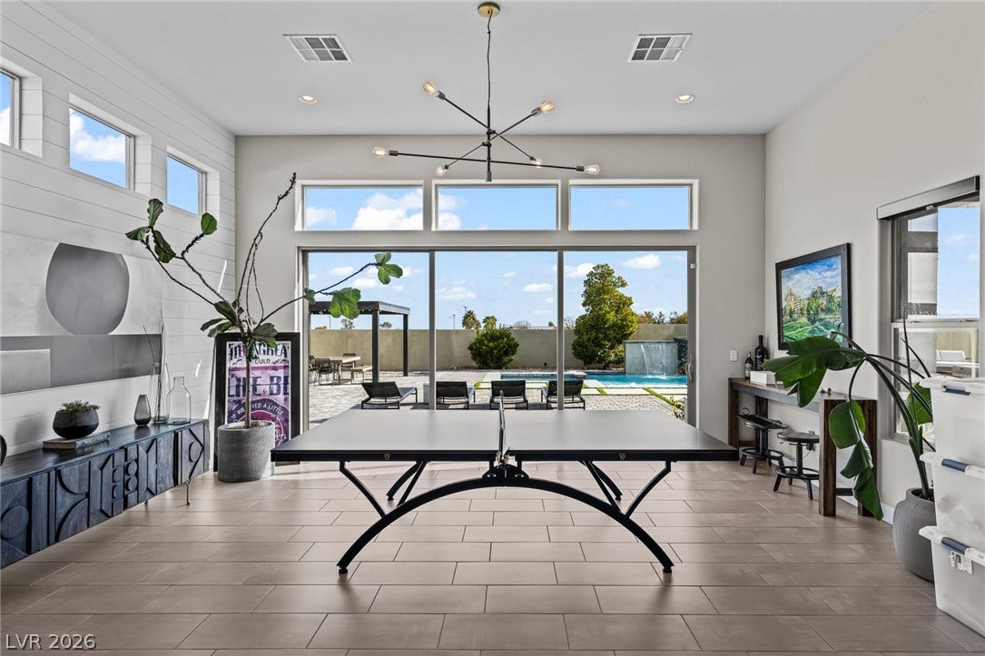 7851 W Wigwam Avenue, Las Vegas, NV 89113 Recreation room featuring a chandelier, a high ceiling, and wood finish floors