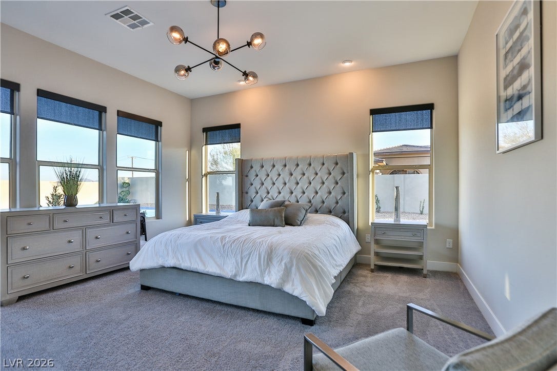 7851 W Wigwam Avenue, Las Vegas, NV 89113 Carpeted bedroom featuring a chandelier and multiple windows