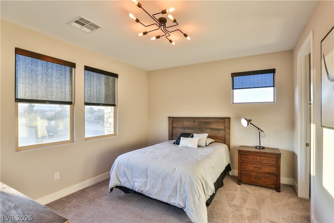 7851 W Wigwam Avenue, Las Vegas, NV 89113 Bedroom with light carpet and a chandelier