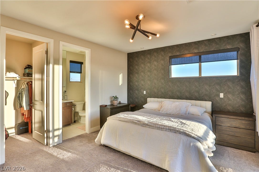 7851 W Wigwam Avenue, Las Vegas, NV 89113 Bedroom featuring an accent wall, wallpapered walls, a chandelier, carpet, and a walk in closet