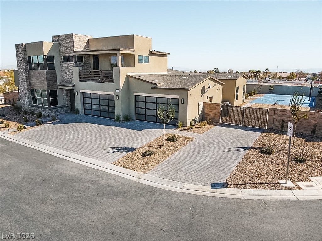 7851 W Wigwam Avenue, Las Vegas, NV 89113 Modern home featuring stone siding, decorative driveway, stucco siding, a gate, and an attached garage