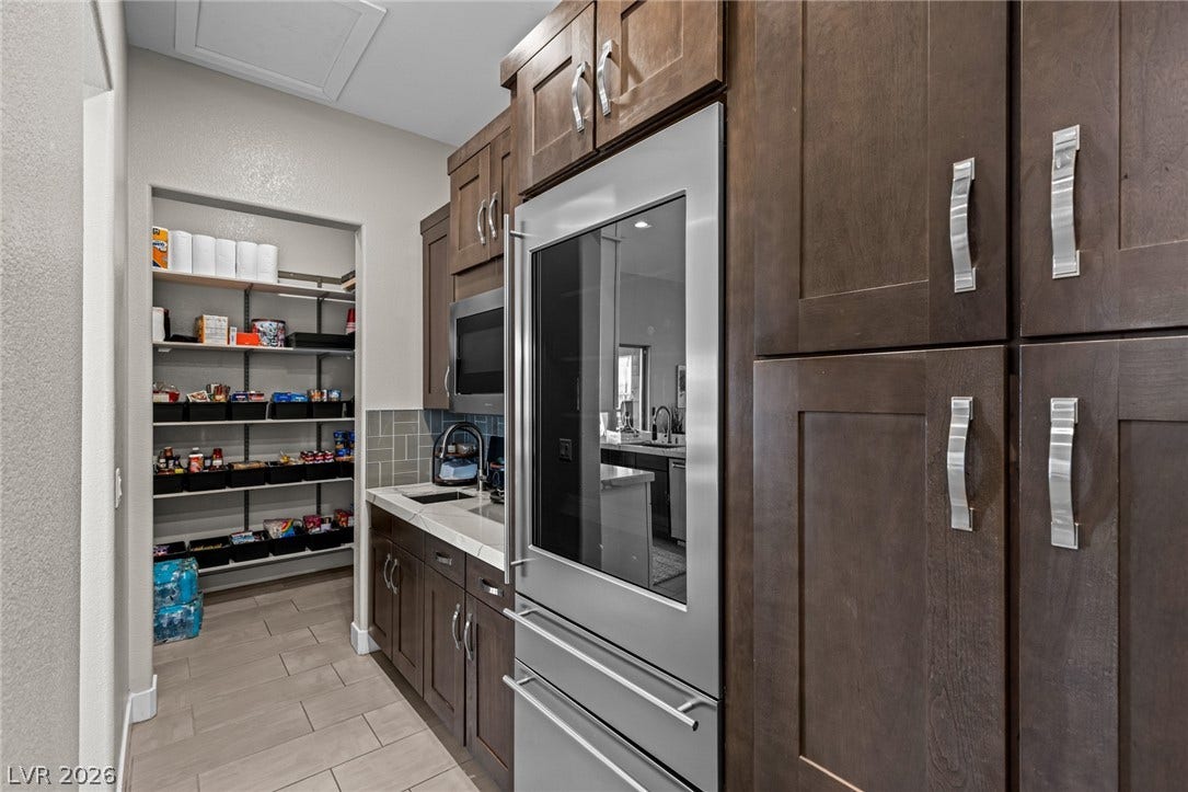 7851 W Wigwam Avenue, Las Vegas, NV 89113 Kitchen featuring backsplash, dark brown cabinetry, and stainless steel appliances