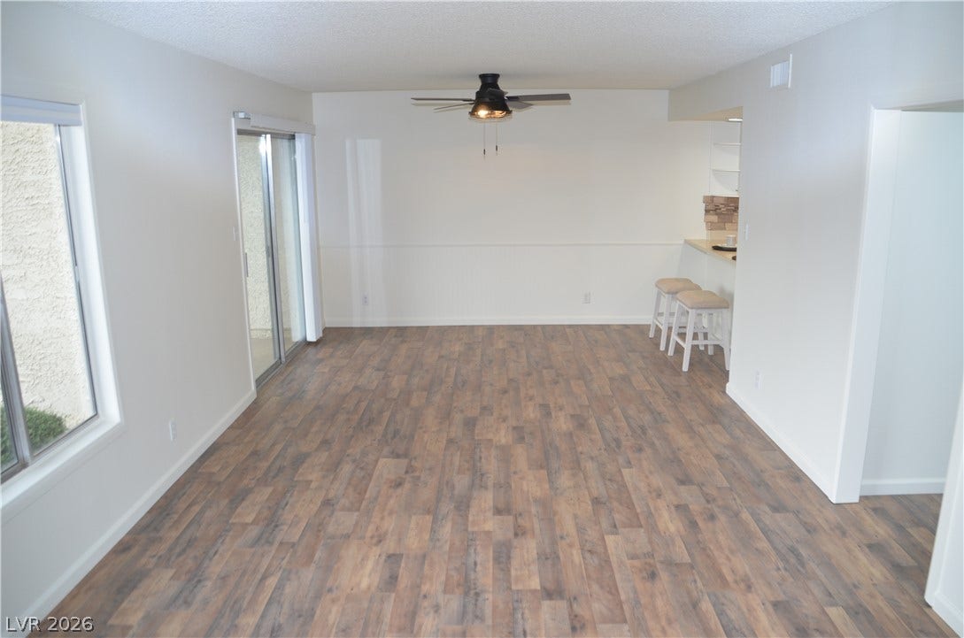 773 Cathy Lane, Henderson, NV 89015 Warm wood-look flooring anchors this open living space featuring large sliding glass doors.