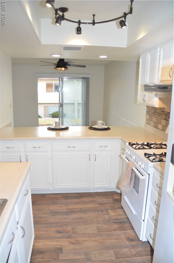 773 Cathy Lane, Henderson, NV 89015 An open kitchen layout features rich wood-style flooring and direct sightlines to the dining area.