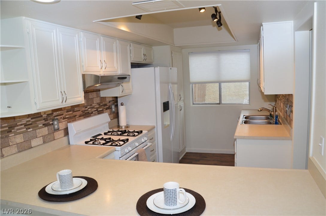 773 Cathy Lane, Henderson, NV 89015 Streamlined cabinetry and classic stone-look backsplash define this efficient culinary workspace.