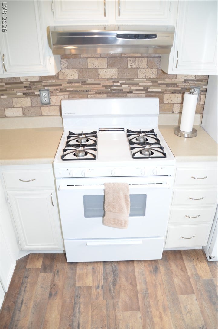 773 Cathy Lane, Henderson, NV 89015 A classic kitchen setup features clean cabinetry above handsome wood flooring and a tiled backsplash.