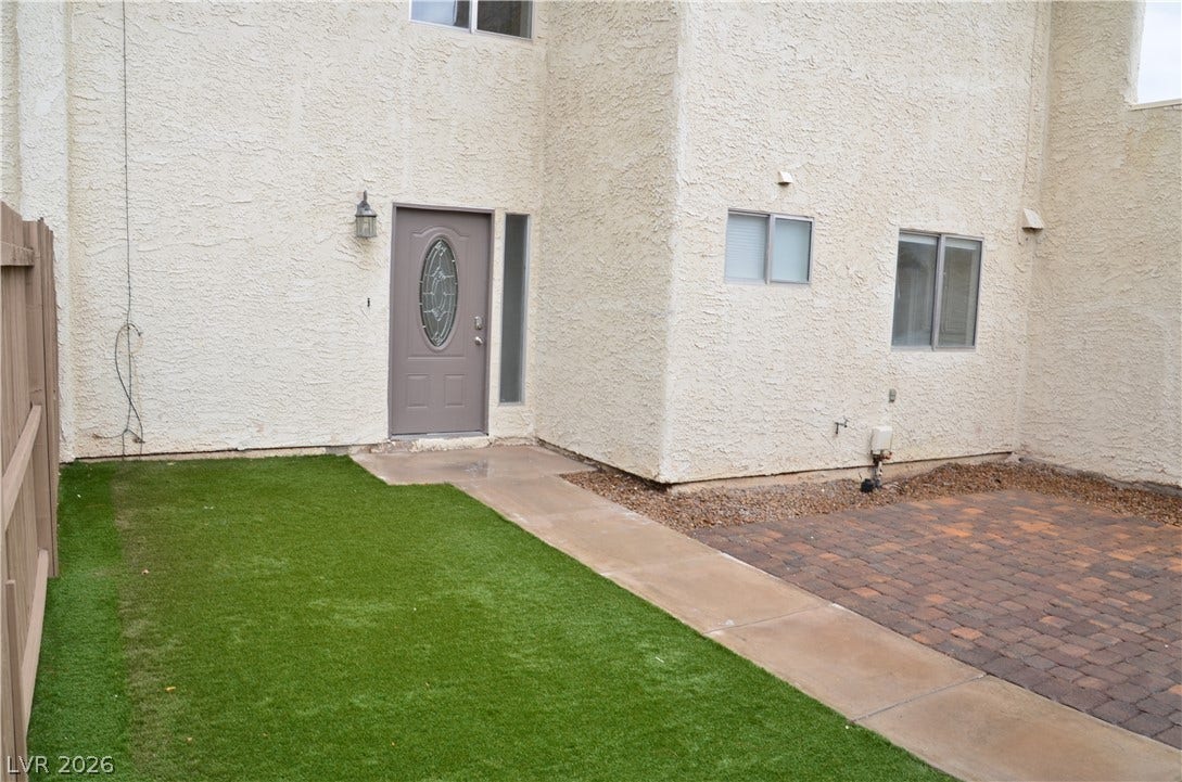 773 Cathy Lane, Henderson, NV 89015 Private stucco courtyard features a tidy paved patio alongside a smooth concrete walkway.