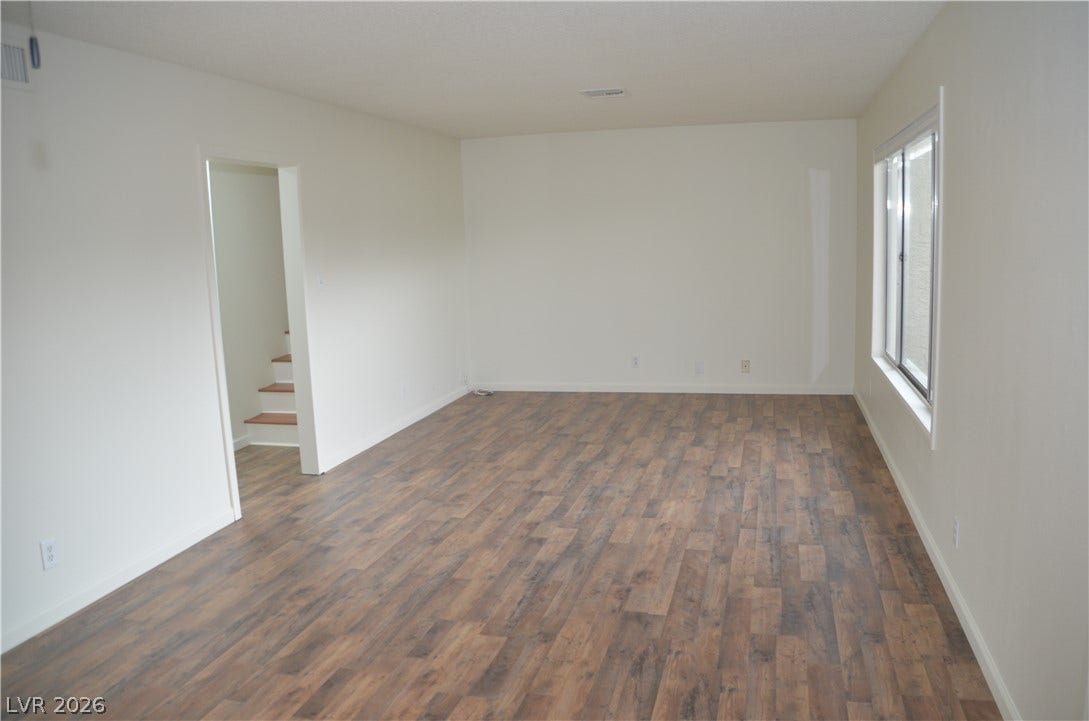 773 Cathy Lane, Henderson, NV 89015 Rich wood-look flooring and a large window define this versatile living space.