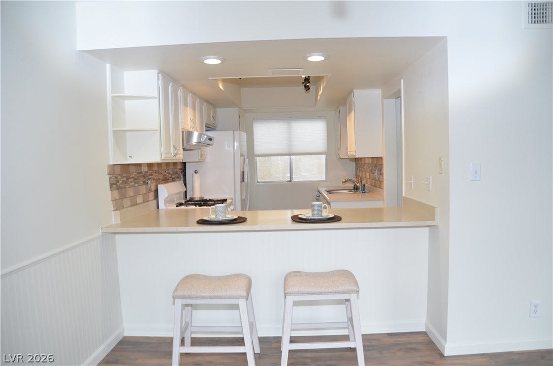 773 Cathy Lane, Henderson, NV 89015 An open breakfast bar overlooks the functional kitchen area with rich wood-look flooring.