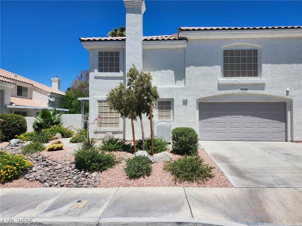 Stucco exterior and Spanish tile roof highlight this multi-level home featuring low-maintenance desert landscaping.