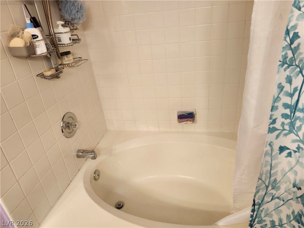 A deep soaking tub is framed by classic tile surrounds.
