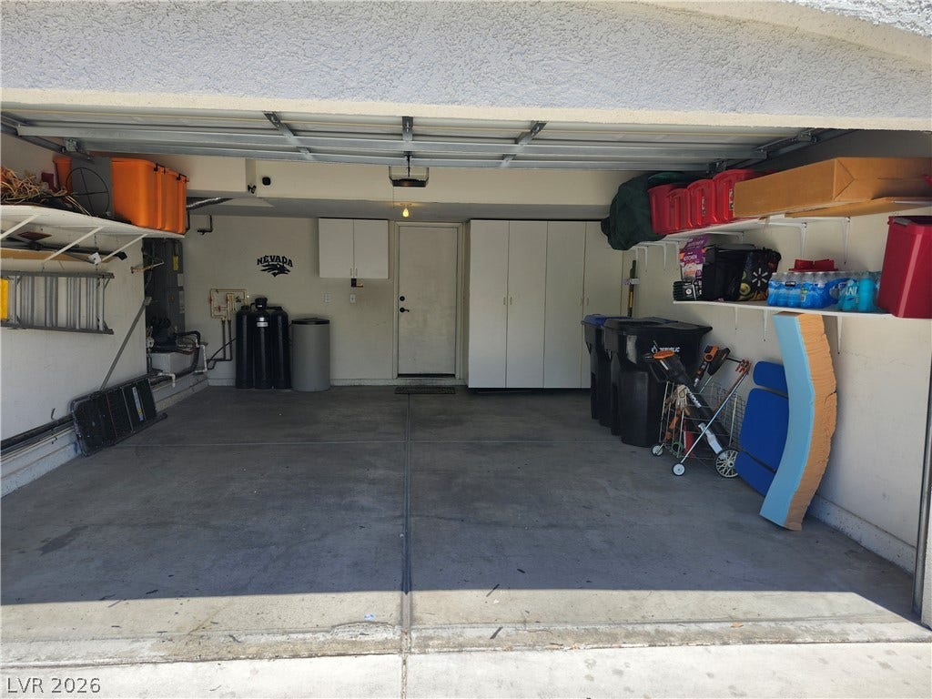 An attached garage provides durable concrete flooring along with convenient built-in storage cabinets.