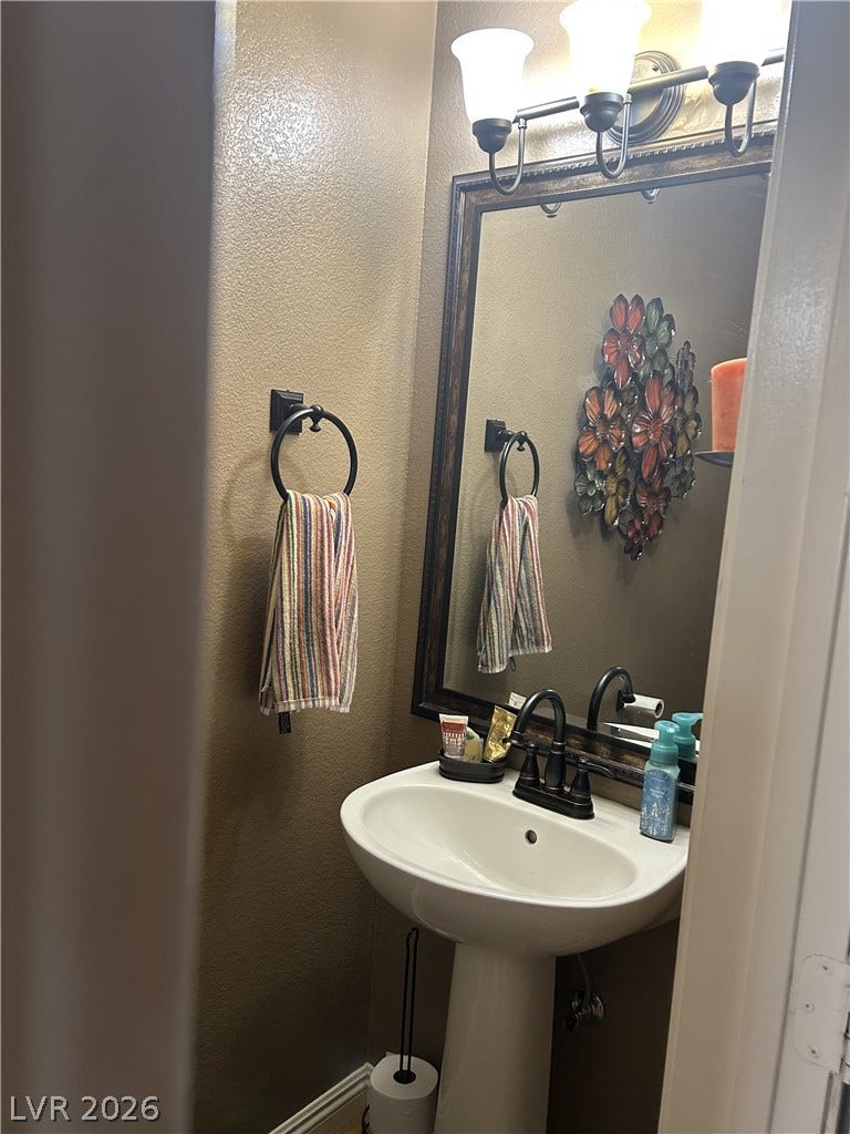 Warm earth tones and classic oil-rubbed bronze fixtures define this cozy half bath.