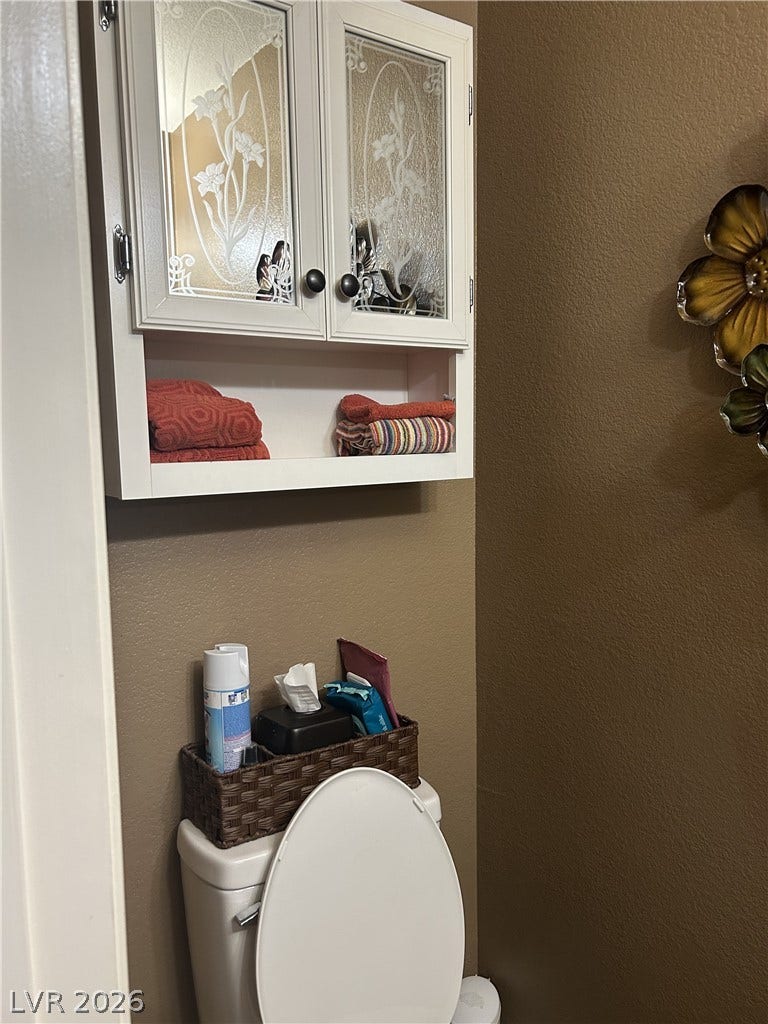 Functional wall cabinetry maximizes storage within this compact powder room layout.