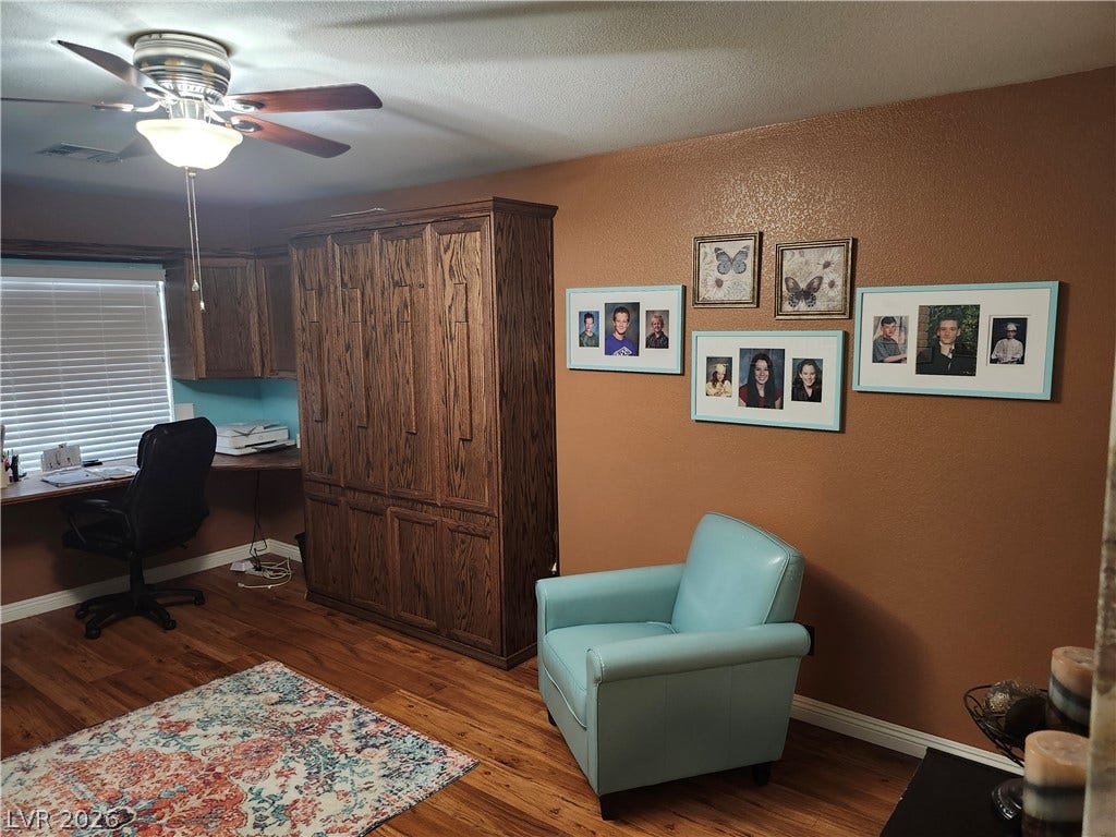 Rich hardwood flooring complements a built-in workspace and substantial cabinetry.
