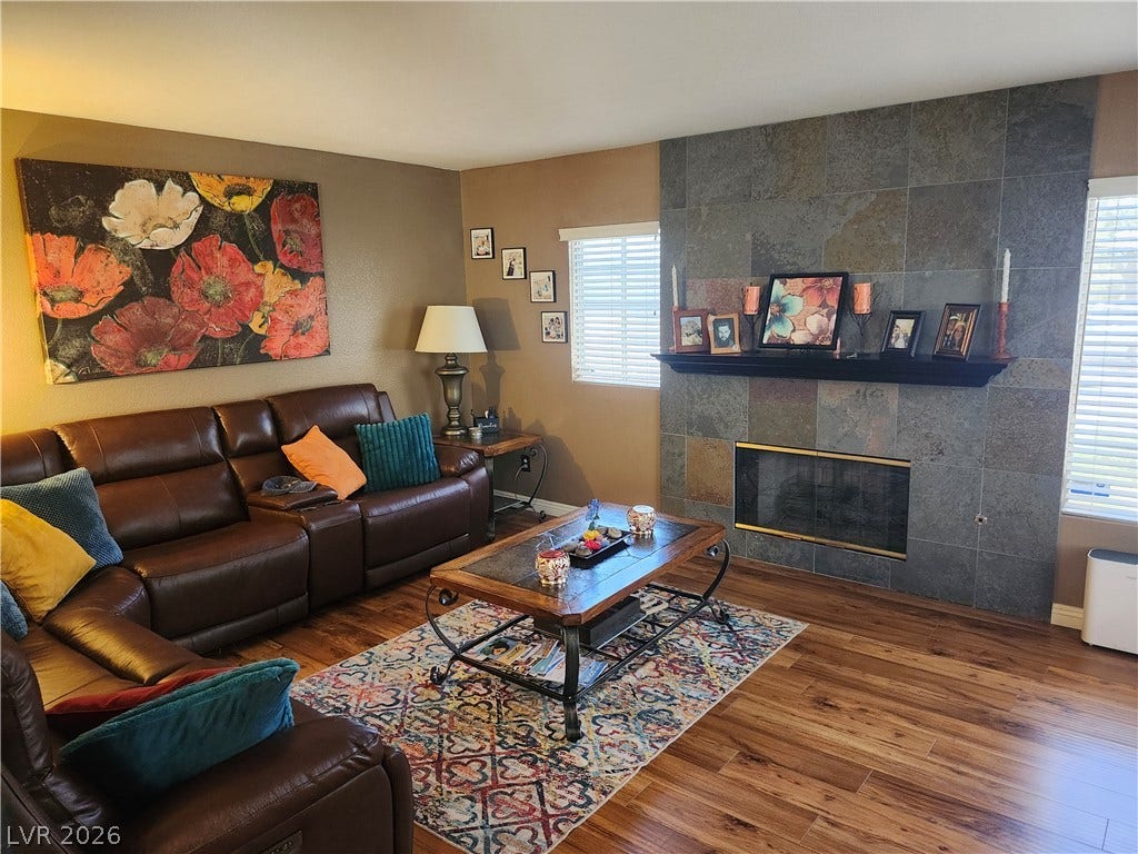 Rich hardwood flooring complements a striking floor-to-ceiling stone tile fireplace surround.