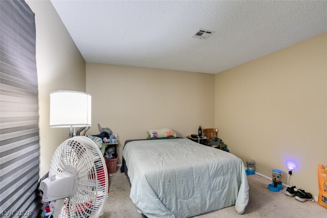 A quiet bedroom offers neutral walls and wall-to-wall carpeting.