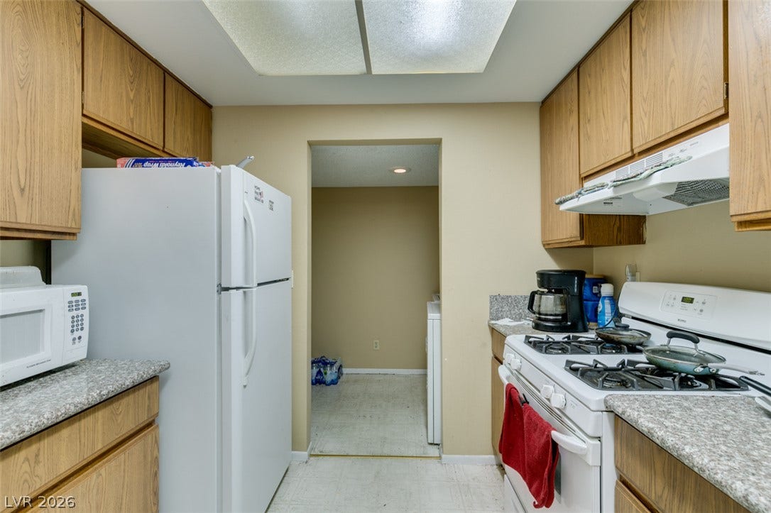 Functional kitchen spaces lead directly into a convenient adjoining laundry room.