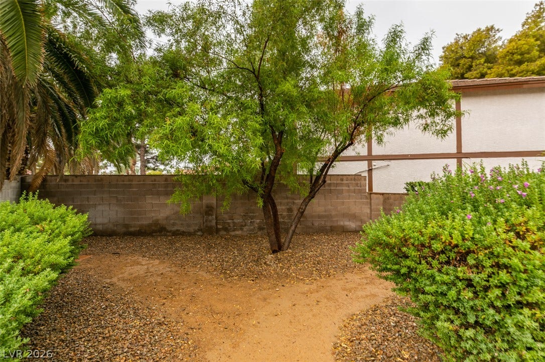 Mature trees and low-maintenance gravel ground cover define this private outdoor space.